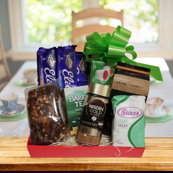 afternoon tea gift hamper on kitchen table, filled with teas, coffees, cake, sugar and biscuits